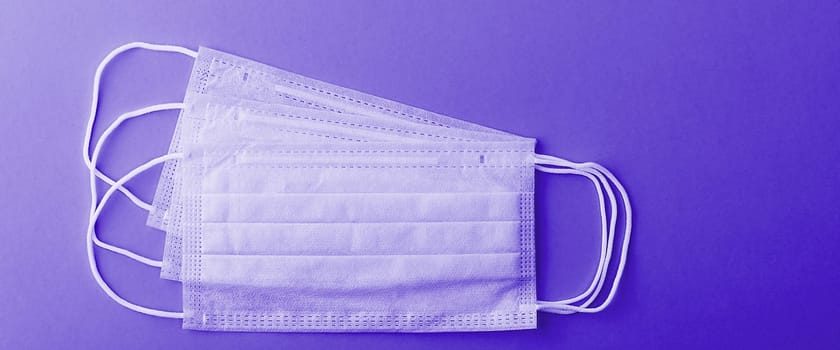 Medical mask surgical protective virus, flu, disease, textile filter. Isolated on a violet background.