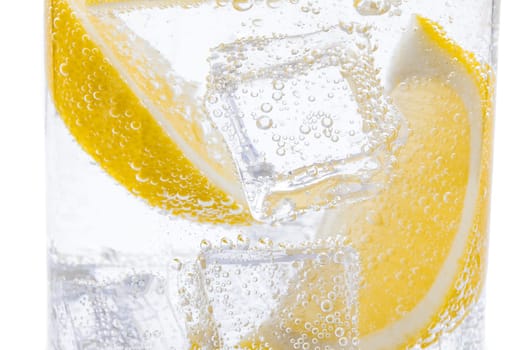Slices of fresh juicy yellow lemon with ice in water.