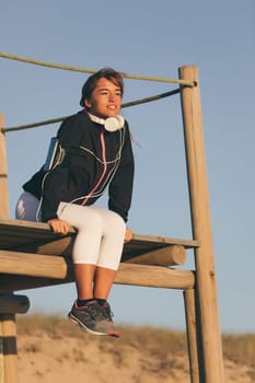 Young beautiful chinese woman exercising at the beach at sunrise/sunset