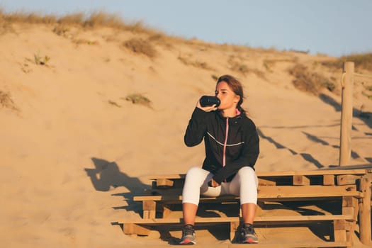 Young beautiful chinese woman exercising at the beach at sunrise/sunset