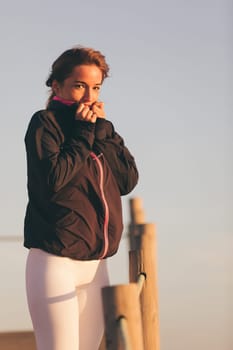 Young beautiful chinese woman exercising at the beach at sunrise/sunset