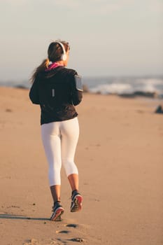 Young beautiful chinese woman exercising at the beach at sunrise/sunset