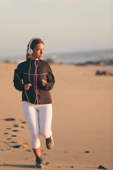 Young beautiful chinese woman exercising at the beach at sunrise/sunset