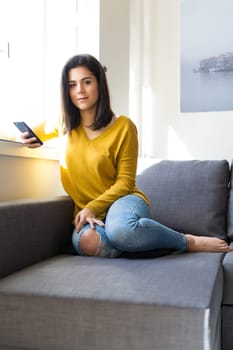 Woman relaxing on couch and making a phone call