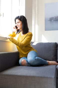 Woman relaxing on couch and making a phone call
