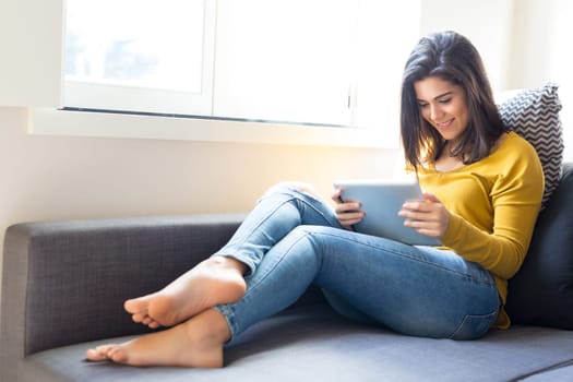 Beautiful young woman relaxing at the living room