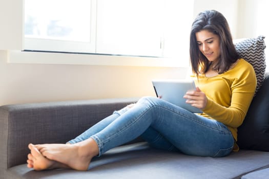 Beautiful young woman relaxing at the living room