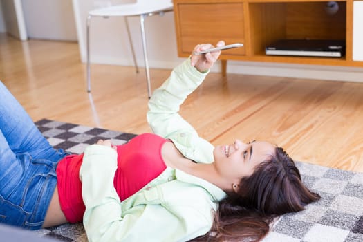 Woman updating her social networks while relaxing in the living room