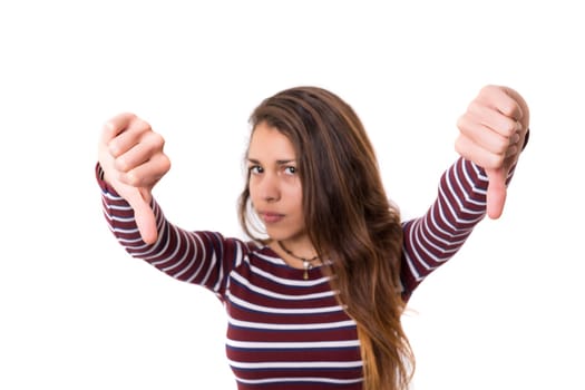 Studio shot of a young woman signaling thumbs down