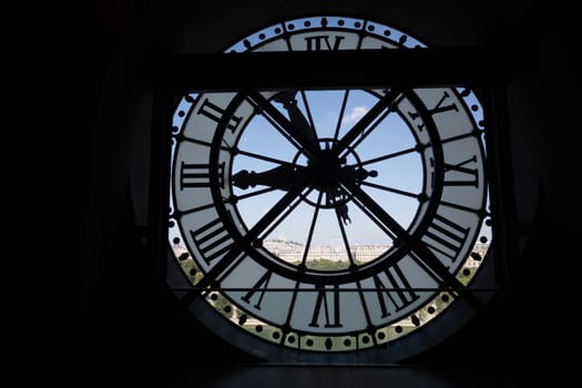 Clock at the Musee D'Orsay in Paris France. In the back we see the Sacre Coeur Basilica in Montmatre