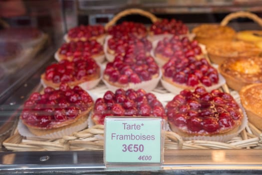 Local patiserie in Paris showing the typical french pastries: raspberry pies