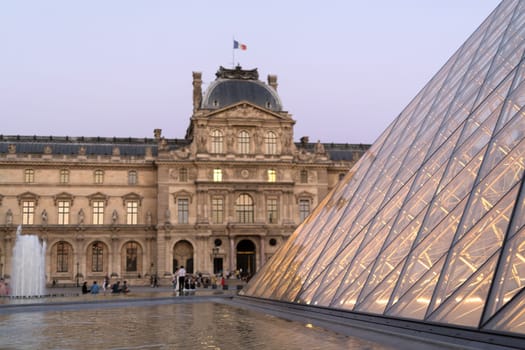 PARIS - AUGUST 15, 2016 Louvre museum at twilight in summer. Louvre Museum is one of the world's largest museums, every year museum visits are more than 8 million visitors.