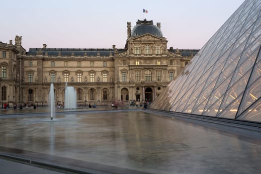 PARIS - AUGUST 15, 2016 Louvre museum at twilight in summer. Louvre Museum is one of the world's largest museums, every year museum visits are more than 8 million visitors.