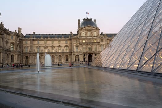 PARIS - AUGUST 15, 2016 Louvre museum at twilight in summer. Louvre Museum is one of the world's largest museums, every year museum visits are more than 8 million visitors.