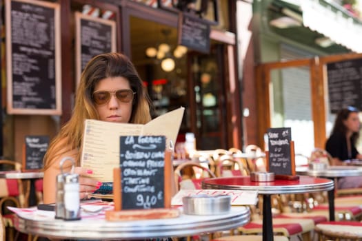 Beautiful young woman at a typical french restaurant