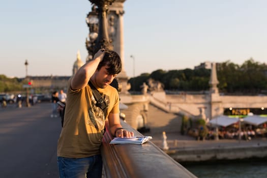Young man on vacations in Paris, relaxing over the Alexander the 3rd bridge
