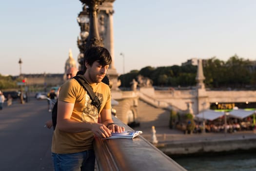 Young man on vacations in Paris, relaxing over the Alexander the 3rd bridge