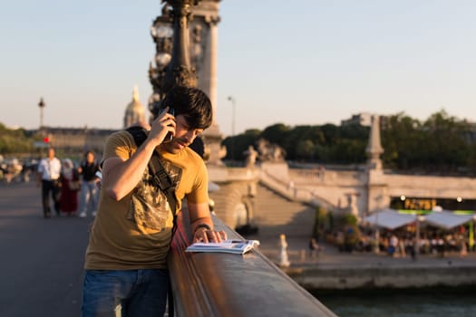 Young man on vacations in Paris, relaxing over the Alexander the 3rd bridge