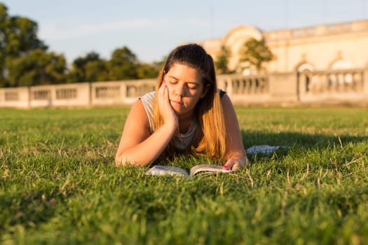 Lucky girl relaxing in the gardens next to the Invalides and the Alexander the 3rd bridge in Paris at the sunset