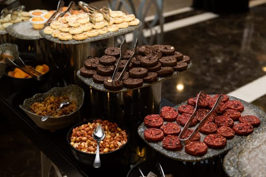 Buffet table with various cookies and biscuits, tarts and cakes.