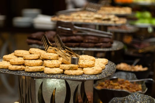 Buffet table with various cookies and biscuits, tarts and cakes.