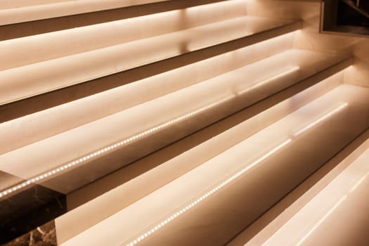 LED illumination of steps of a marble staircase, close up view.