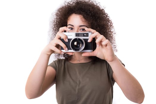 Beautiful woman holding a vintage camera, isolated over white background