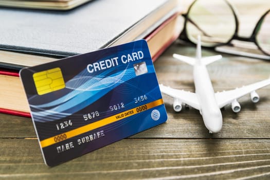 Credit card and airplane model on wooden table , Preparation for Traveling concept