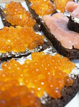 Red caviar on black bread with butter - photo