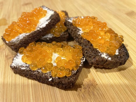 Red caviar on black bread with butter - photo