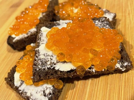 Red caviar on black bread with butter - photo