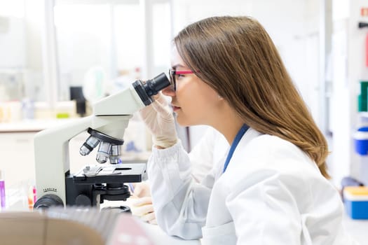 Beautiful young scientist working at the laboratory