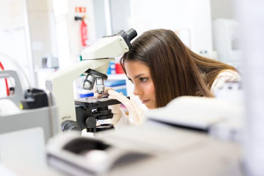 Beautiful young scientist working at the laboratory