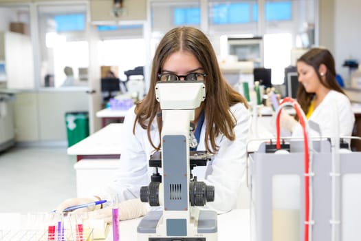 Beautiful young scientist working at the laboratory