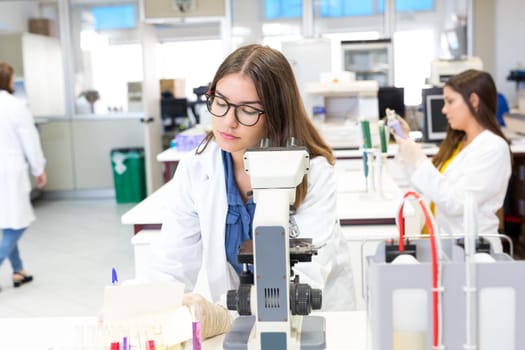 Beautiful young scientist working at the laboratory