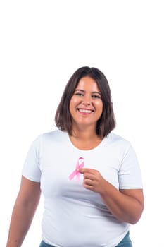 Caucasian girl holding breast cancer ribbon over a white background smiling.