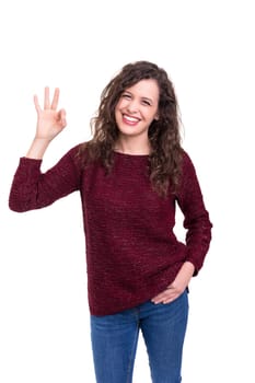 Beautiful young woman signaling ok, isolated over white