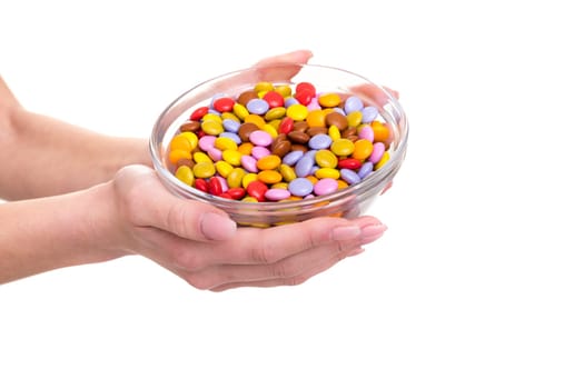 Young woman holding a bow of colorful chocolate candies, isolated over white background