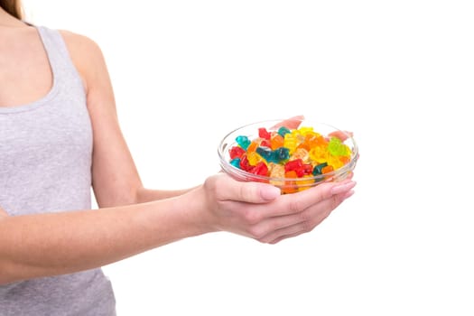 Young woman holding a bowl of jelly gummy bears, isolated over white background
