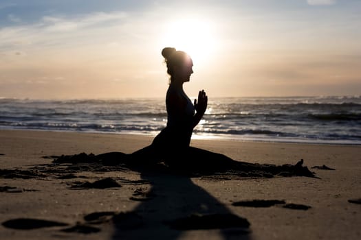 Sporty young woman doing yoga practice at the beach - concept of healthy life and natural balance between body and mental development