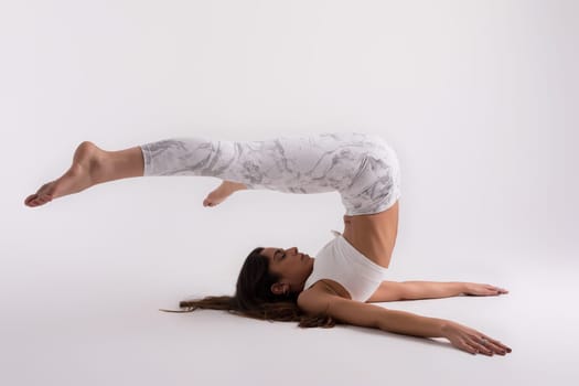 Sporty young woman doing yoga practice isolated on white background - concept of healthy life and natural balance between body and mental development