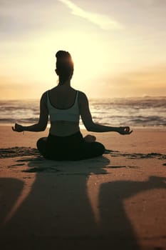 Sporty young woman doing yoga practice at the beach - concept of healthy life and natural balance between body and mental development