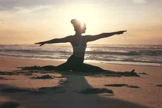 Sporty young woman doing yoga practice at the beach - concept of healthy life and natural balance between body and mental development