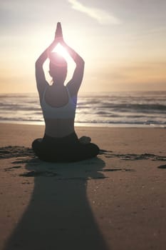 Sporty young woman doing yoga practice at the beach - concept of healthy life and natural balance between body and mental development