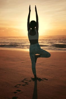 Sporty young woman doing yoga practice at the beach - concept of healthy life and natural balance between body and mental development