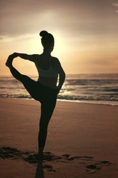 Sporty young woman doing yoga practice at the beach - concept of healthy life and natural balance between body and mental development