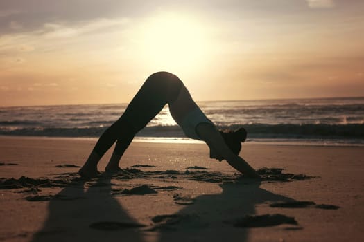 Sporty young woman doing yoga practice at the beach - concept of healthy life and natural balance between body and mental development