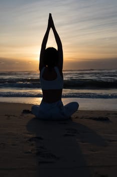 Sporty young woman doing yoga practice at the beach - concept of healthy life and natural balance between body and mental development