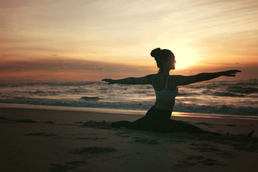 Sporty young woman doing yoga practice at the beach - concept of healthy life and natural balance between body and mental development