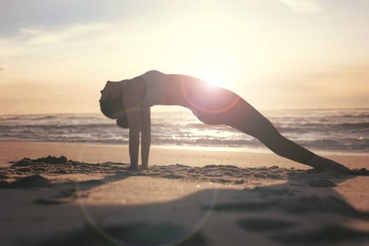 Sporty young woman doing yoga practice at the beach - concept of healthy life and natural balance between body and mental development